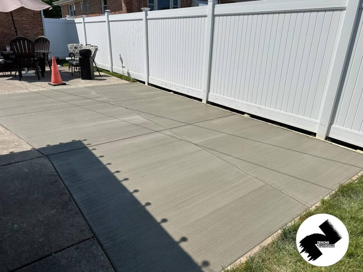 Concrete patio poured up to a property fence